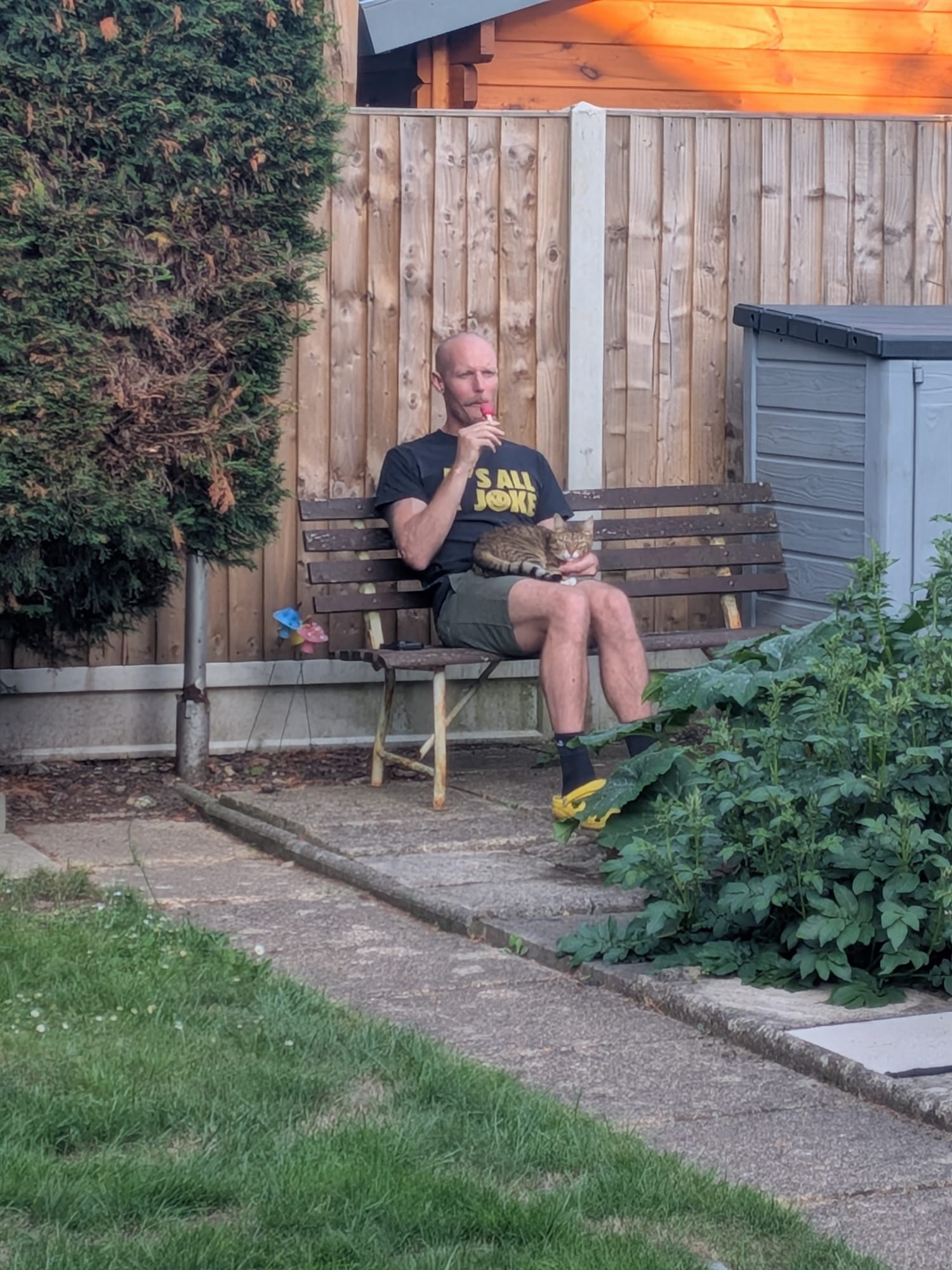 James relaxing on a garden bench with Kiki the cat on his lap